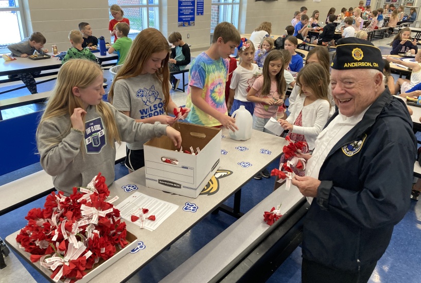Wilson students help a veteran hand out Memorial Poppies